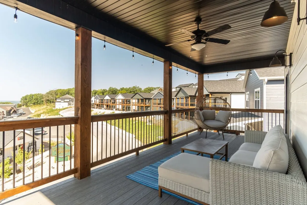 This exterior image shows a comfortable outdoor seating area with hanging light fixtures and views of the surrounding homes. The atmosphere is casual and welcoming, inviting guests to relax outside after a day exploring Branson’s attractions.